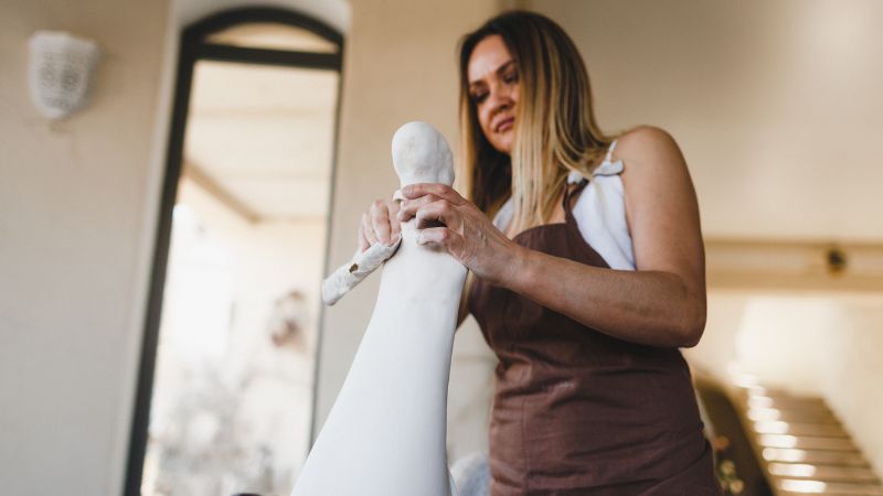 woman sculpting clay into figure