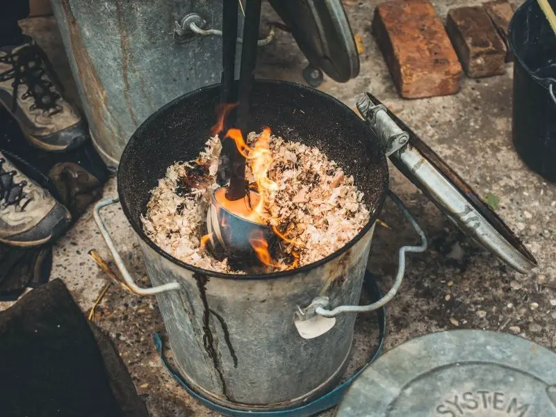 firing pottery mug in wood shavings